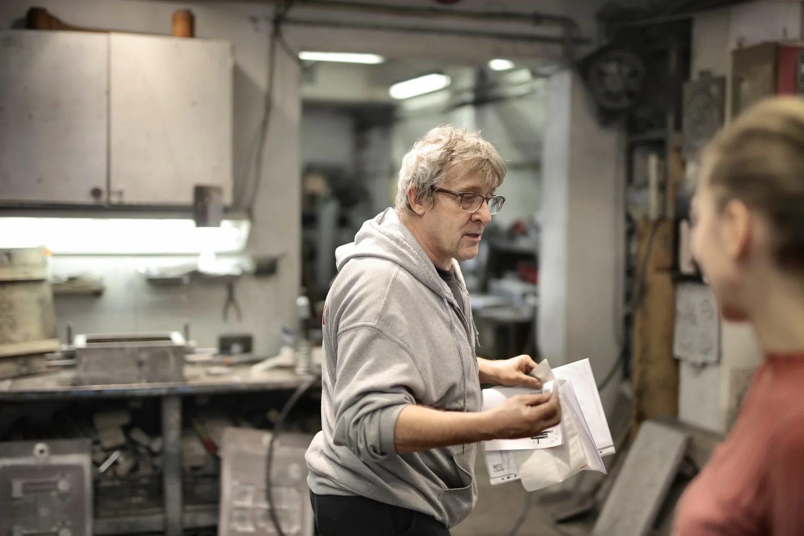 Two tradespeople discussing documents in a workshop