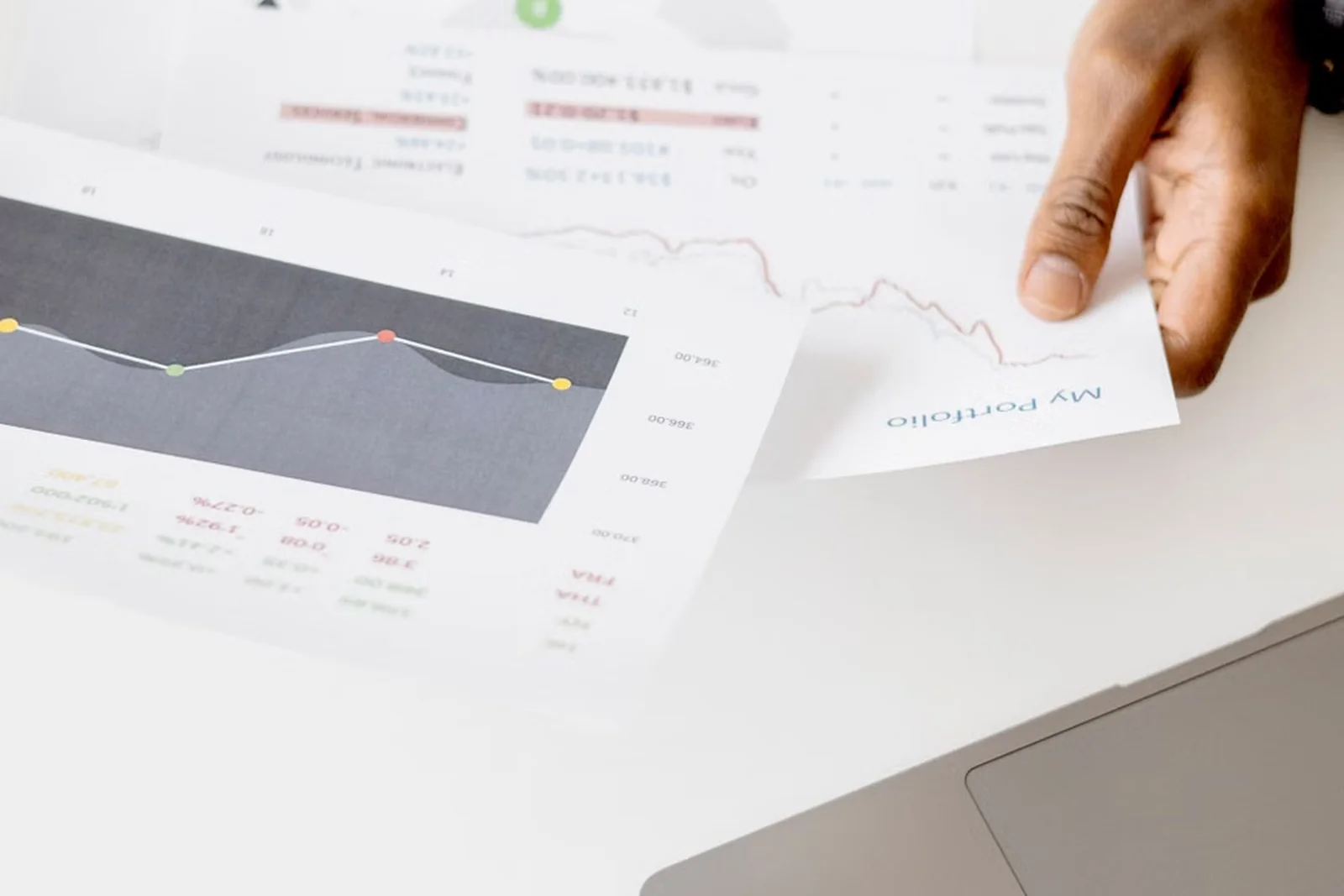 Analyst reviewing charts alongside a laptop