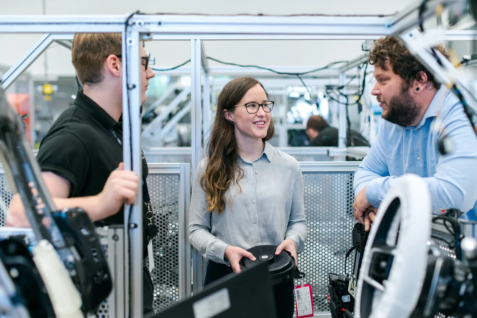 Engineering team discussing work together on a factory floor