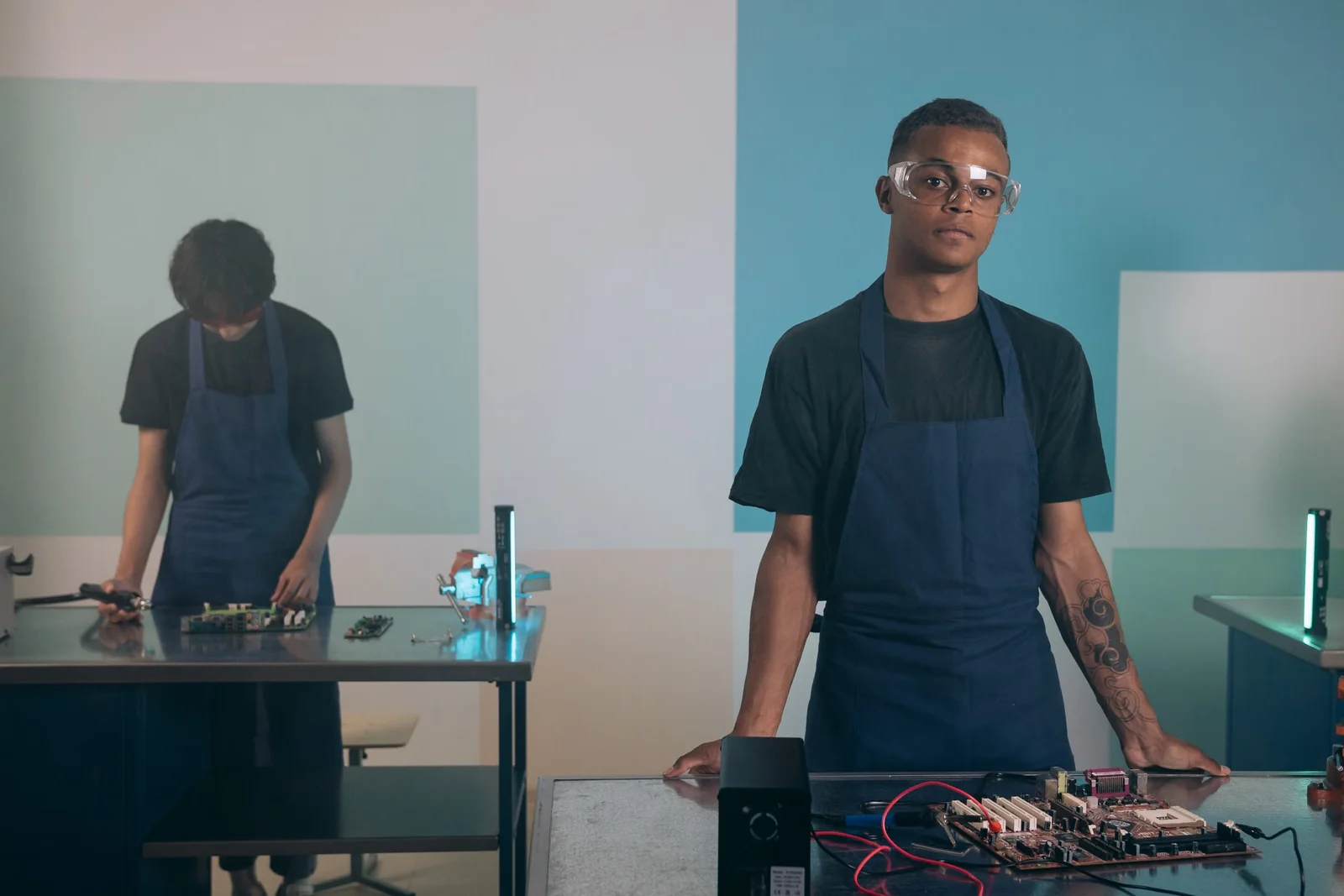 Two technicians learning and working with electronics in a workshop