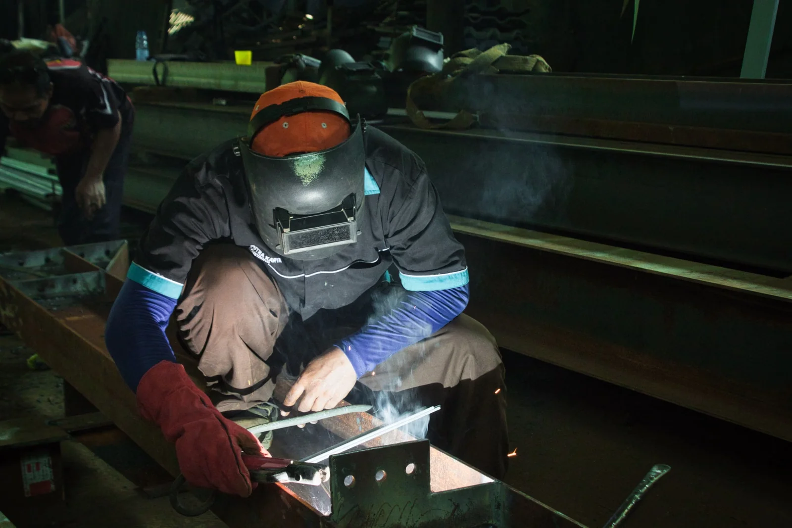 Welder wearing protective equipment while working with metal